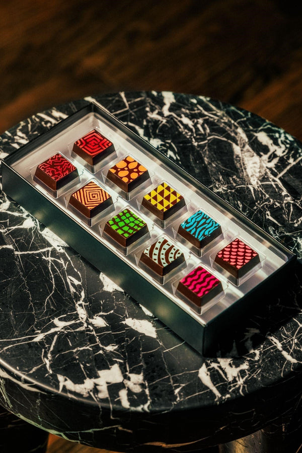 10 piece box of truffles on black granite table — Compartes