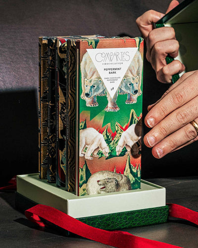 A person holds a Compartés’ Christmas Chocolate Green Gift Box.