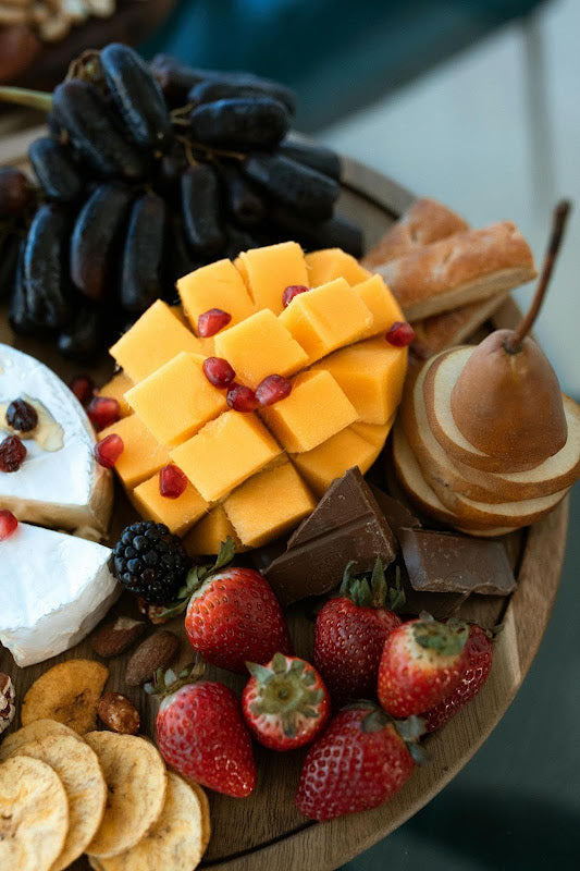 A charcuterie board featuring fruits, cheese, and chocolate – Compartés