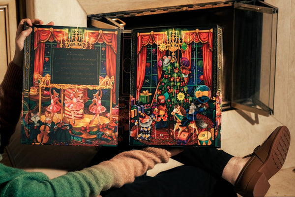 Man sitting with leg up holding opened advent calendar by Compartés