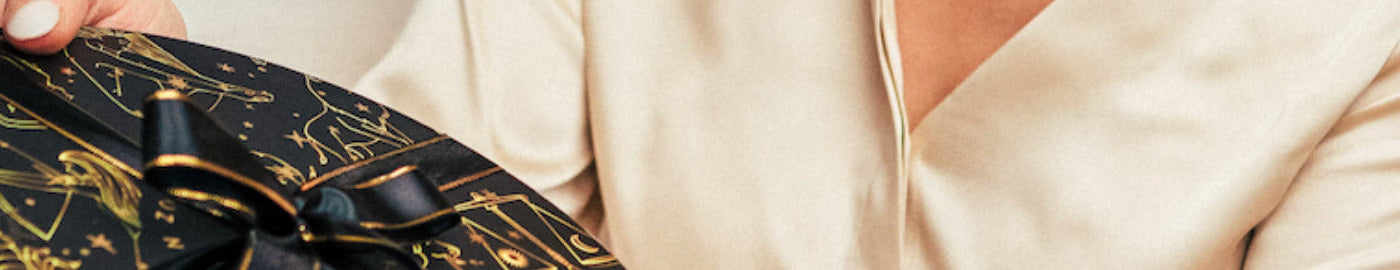 Person receiving box of chocolates wrapped in a bow