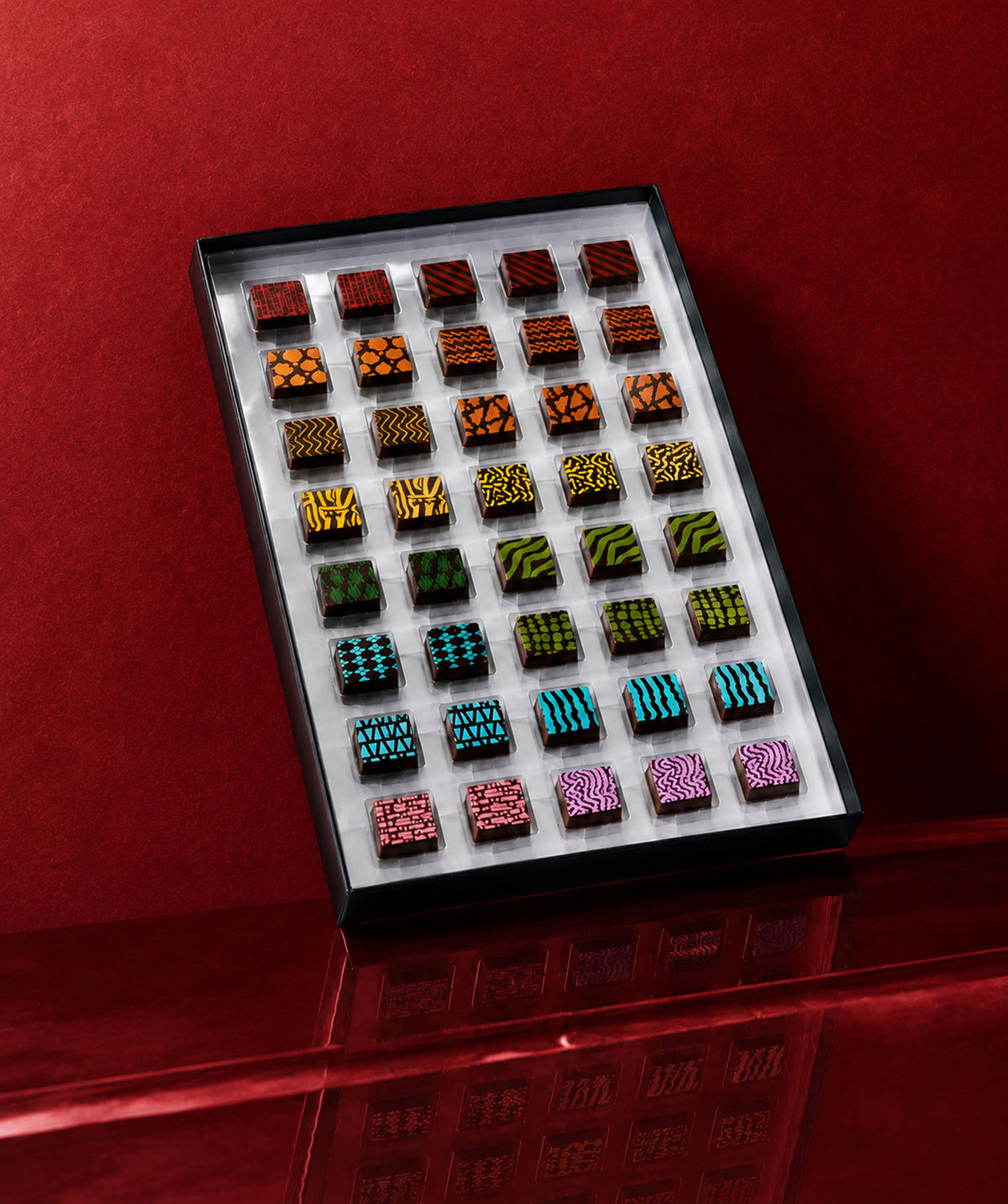 A luxury chocolate gift box featuring chocolate art patterns and prints with gourmet chocolate truffles inside. Colorful luxury chocolates by Compartes Los Angeles.