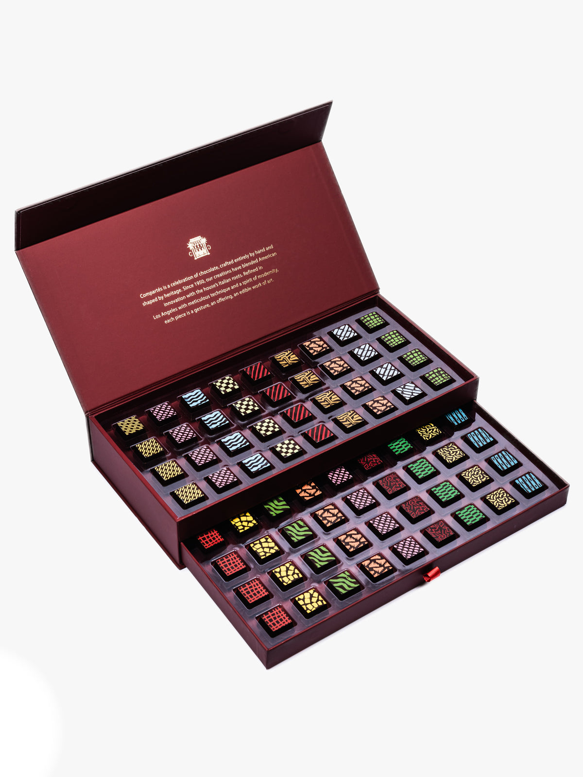 Compartes Burgundy Signature Drawer Collection featuring 80 handcrafted chocolates in a burgundy box with gold foil and geometric designs.