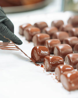 Chocolate covered mashmallows in rows on parchment baking paper