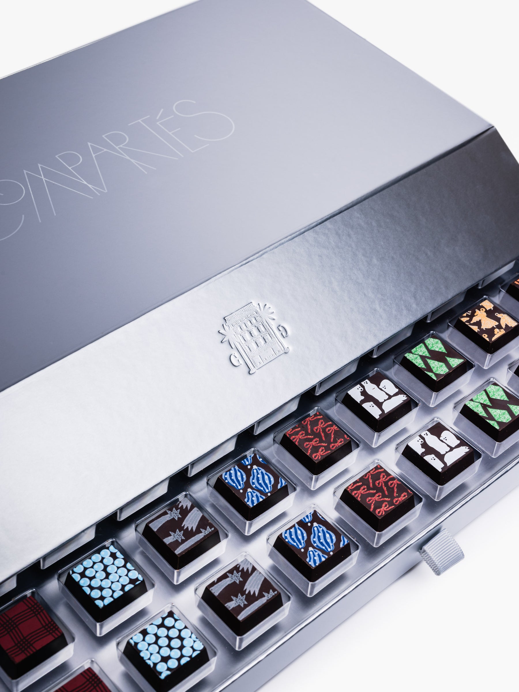 Compartes Silver Holiday Drawer Collection featuring 80 handcrafted holiday chocolates in a metallic silver gift box with seasonal designs.