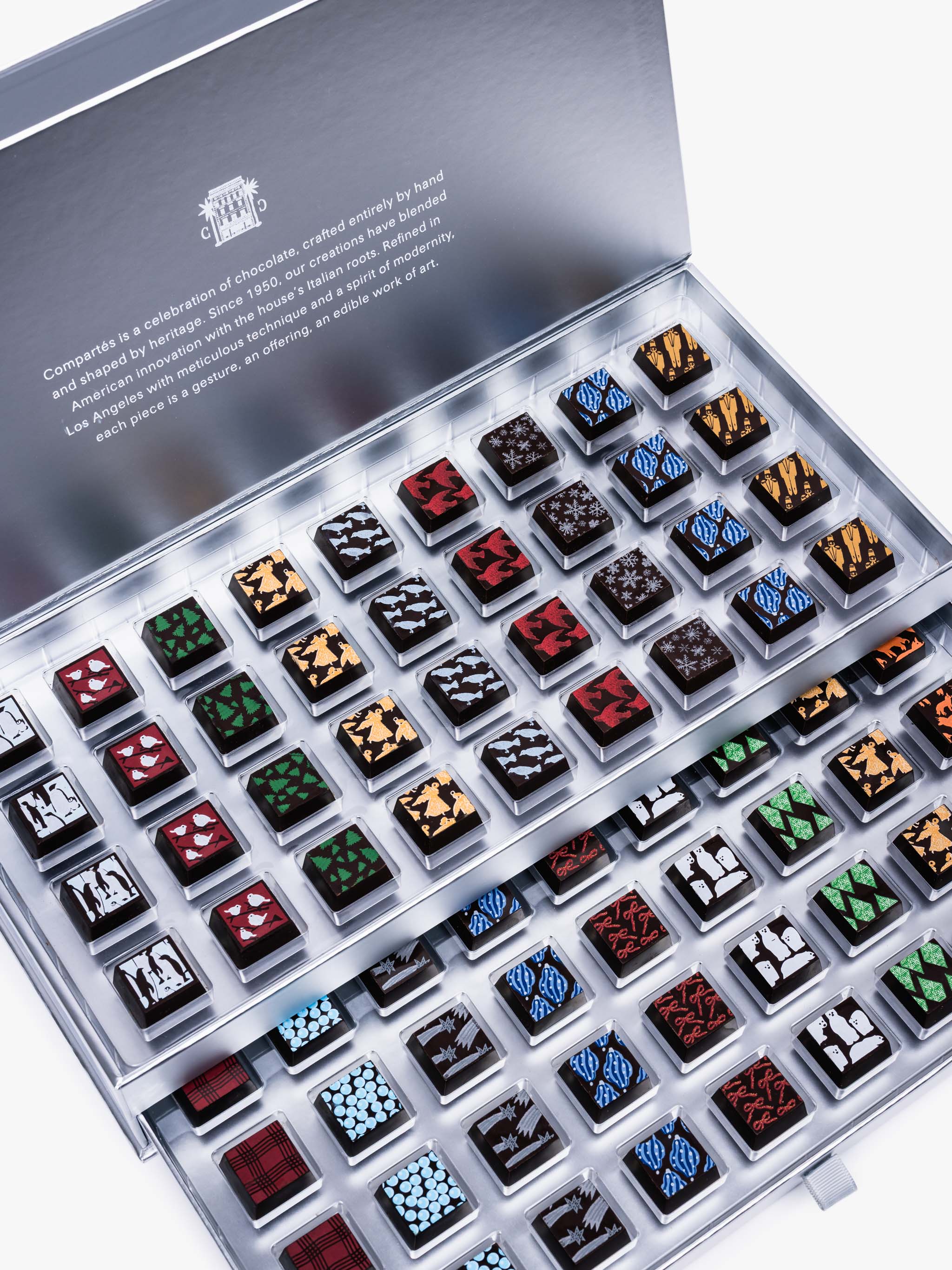 Compartes Silver Holiday Drawer Collection featuring 80 handcrafted holiday chocolates in a metallic silver gift box with seasonal designs.