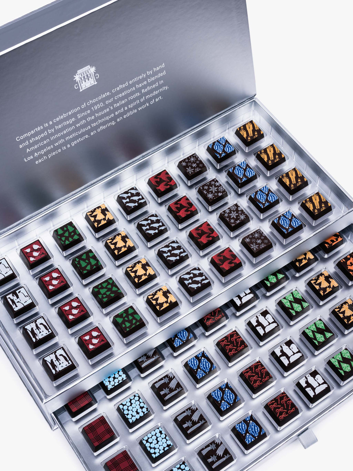 Compartes Silver Holiday Drawer Collection featuring 80 handcrafted holiday chocolates in a metallic silver gift box with seasonal designs.