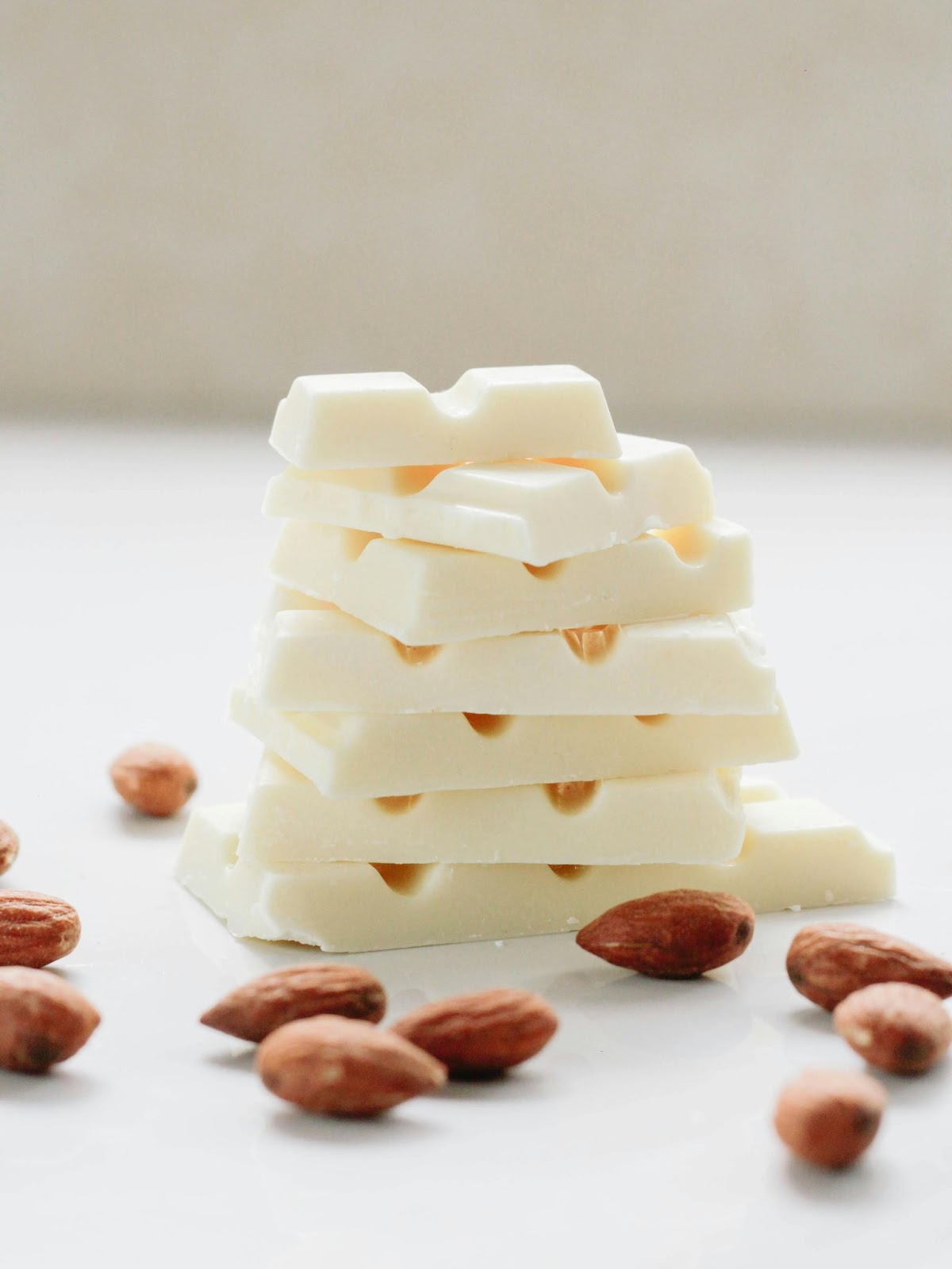 A stack of white chocolate squares and almonds.