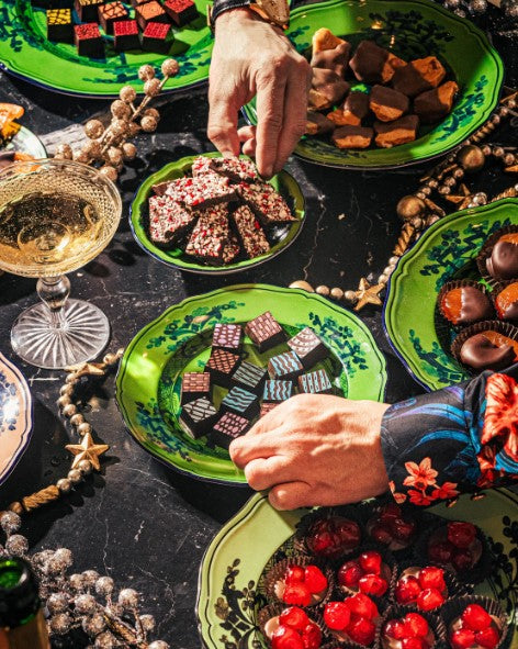 Adults reaching for luxury chocolate with champagne at a dinner party – Compartés