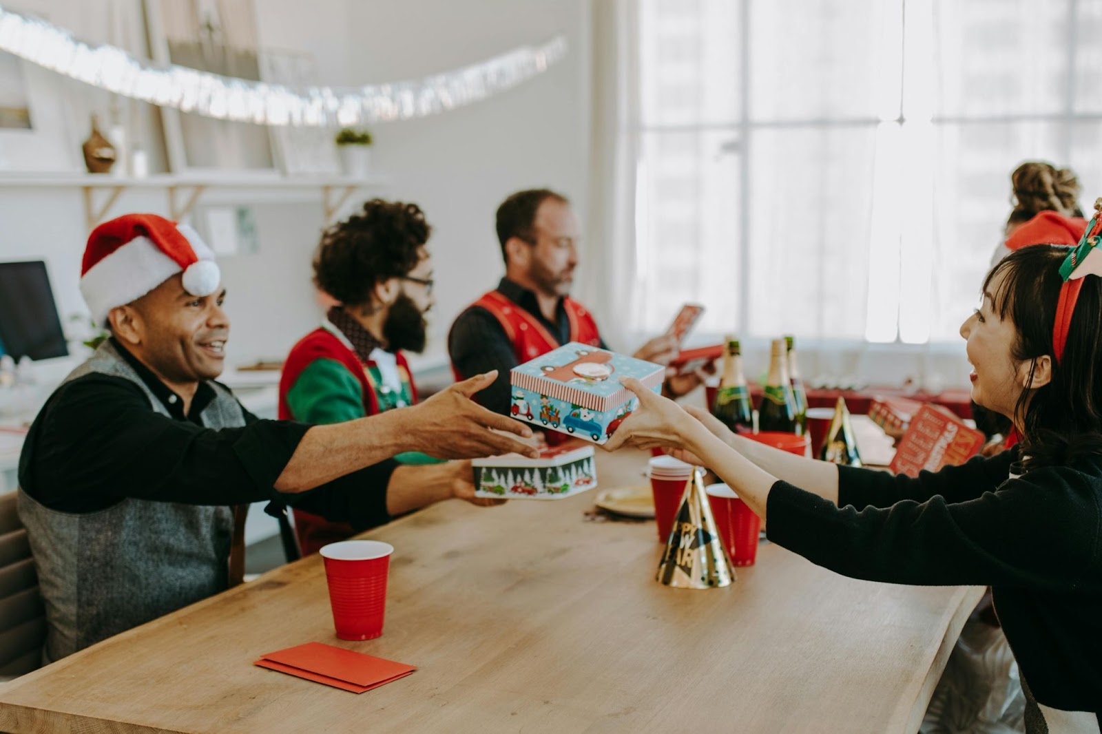 Employees exchange gifts during a holiday office party – Compartés