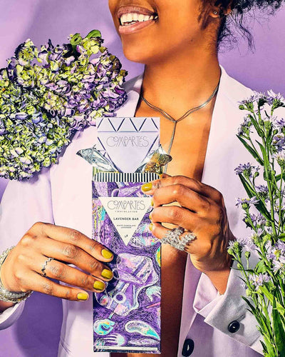 A person in a lavender suit holding the gluten-free Lavender Chocolate Bar – Compartés