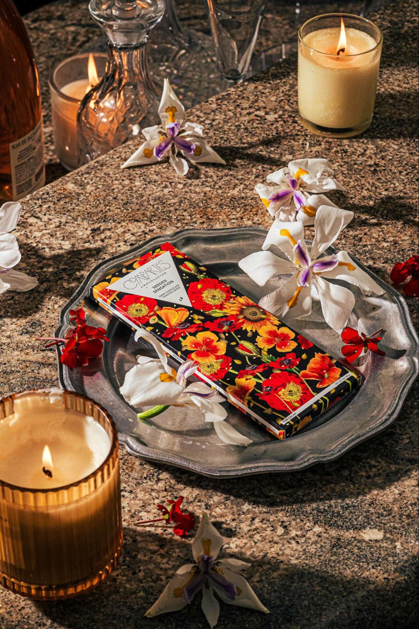Luxury vegan chocolate gift bar from Compartés displayed on a decorative tray with flowers and candlelight, styled as an elegant vegan chocolate gift.