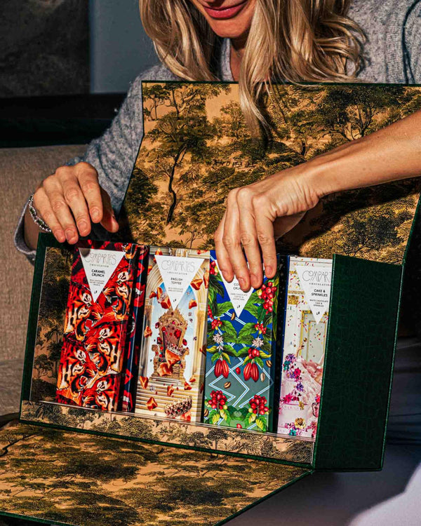 Mother’s Day surprise gift box filled with gourmet chocolate bars being opened by a smiling woman