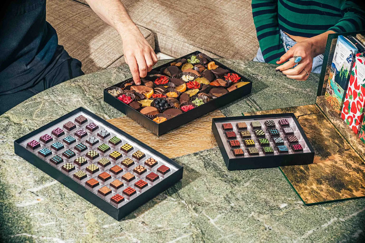 two people selecting chocolate truffles and fruit  – Compartés