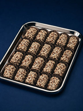 A tray of chocolate-covered english toffee with gourmet dark chocolate and chopped almonds presented in a beautiful tray by Compartes Chocolates Los Angeles.
