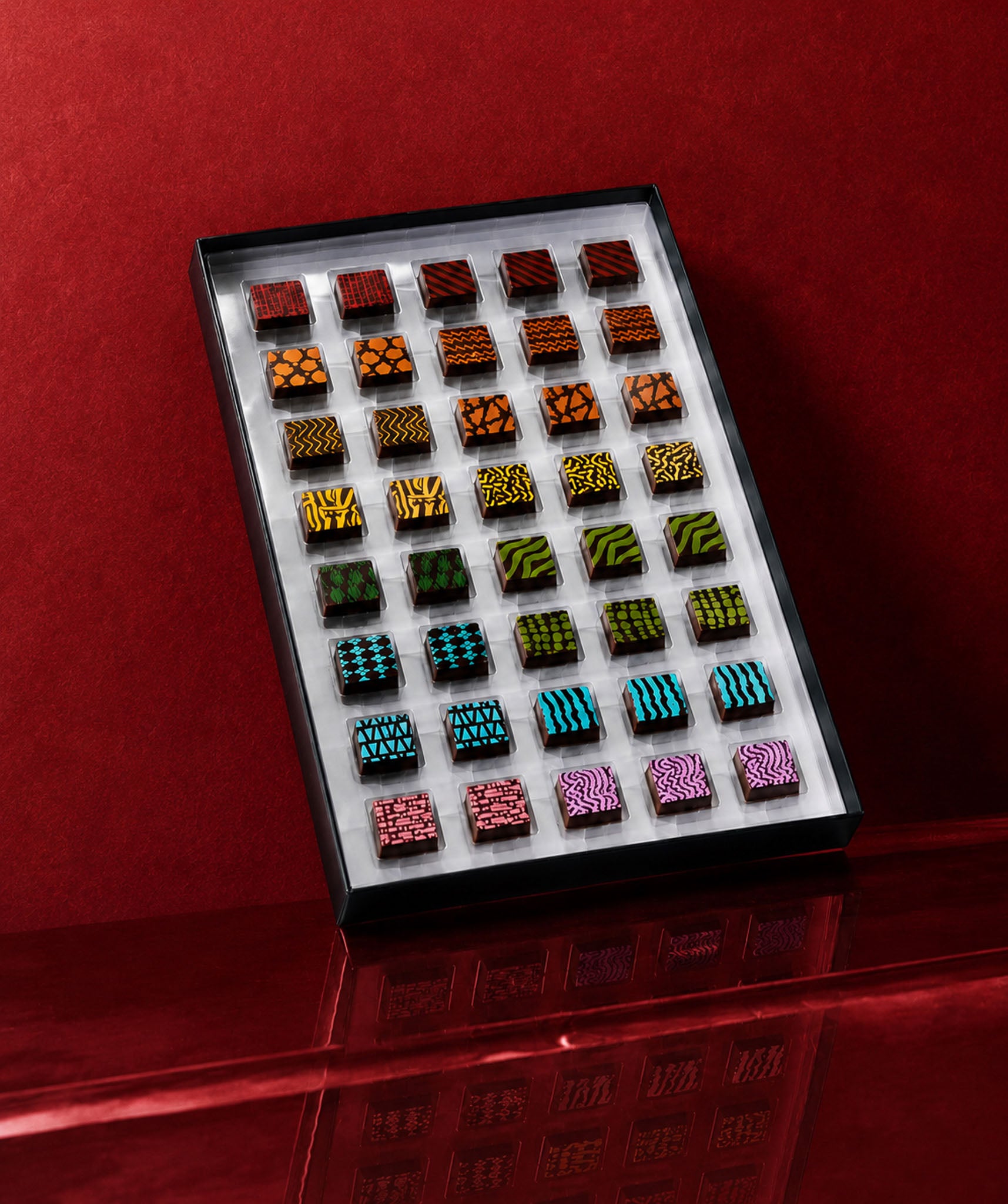 A luxury chocolate gift box featuring chocolate art patterns and prints with gourmet chocolate truffles inside. Colorful luxury chocolates by Compartes Los Angeles.