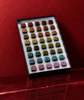 A luxury chocolate gift box featuring chocolate art patterns and prints with gourmet chocolate truffles inside. Colorful luxury chocolates by Compartes Los Angeles.