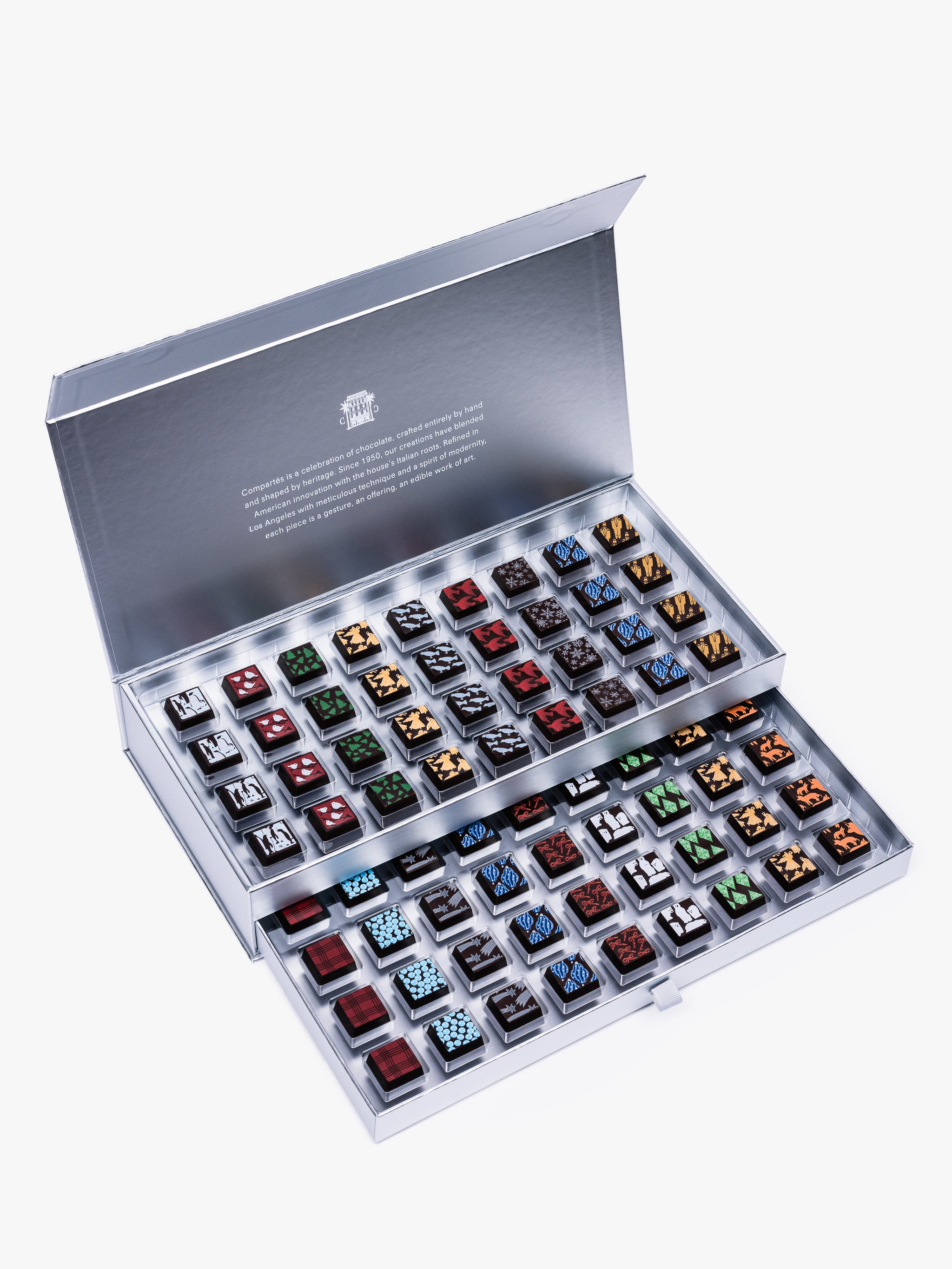 Compartes Silver Holiday Drawer Collection featuring 80 handcrafted holiday chocolates in a metallic silver gift box with seasonal designs.