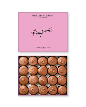 Compartes gourmet peanut butter cups in milk chocolate, swirled tops under a pink lid, chocolate gift