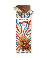 A Compérés Little Debbie oatmeal creme pies bar in its wrapper, with the top foil partially peeled back to reveal a piece of chocolate. The wrapper features a red, white, and blue burst design with an illustration of oatmeal creme pies.