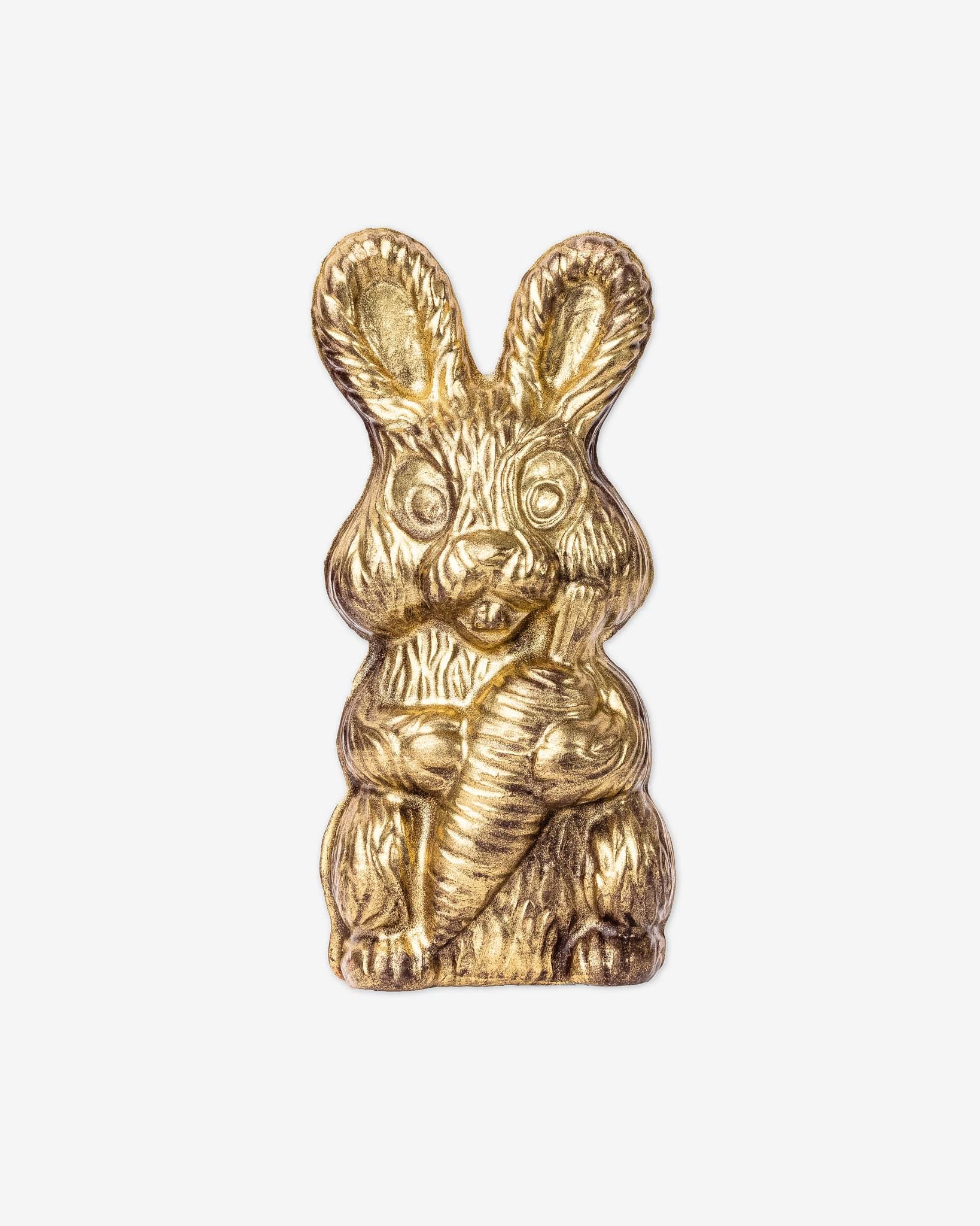 Gold chocolate bunny in front of a white background	
